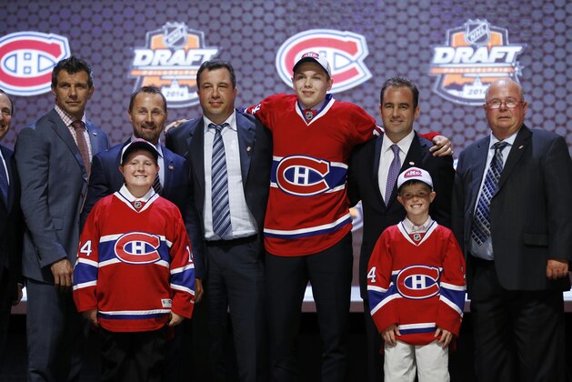 Nikita Scherbak stands with Montreal Canadiens officials after being chosen 26th overall during the first round of the NHL hockey draft, Friday, June 27, 2014, in Philadelphia. (AP Photo/Matt Slocum)