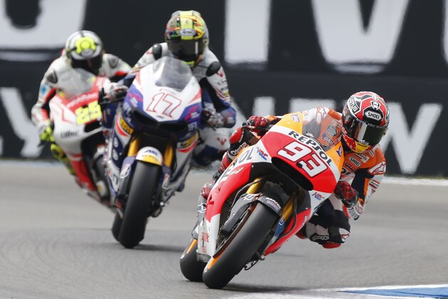 Marc Marquez of Spain, right, competes on his Honda with Karel Abraham of Czech Republic on his Honda, centre, and Andrea Iannone of Italy on his Ducati, left,  during qualifying for the Dutch MotoGP  Grand Prix, in Assen, northern Netherlands, Friday June 27, 2014. (AP Photo/Vincent Jannink)