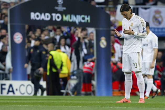 Real Madrid's Mesut Ozil from Germany prays before the start of a semifinal, second leg Champions League soccer match against Bayern Munich at the Santiago Bernabeu stadium in Madrid Wednesday April 25, 2012. (AP Photo/Paul White)