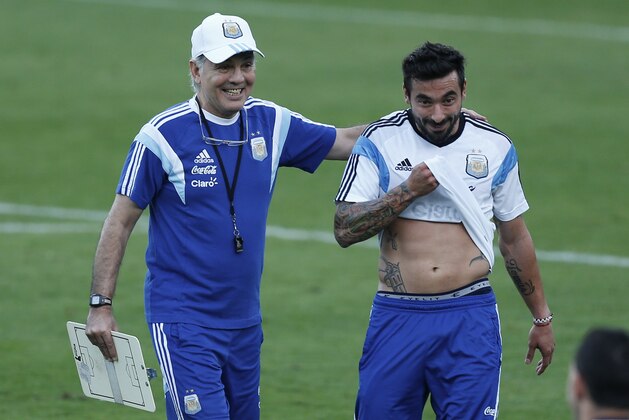 Argentina's head coach Alejandro Sabella, left, pats Ezequiel Lavezzi on the back during a training session in Vespasiano, near Belo Horizonte, Brazil, Monday, June 16, 2014.  Argentina plays in group F of the 2014 soccer World Cup. (AP Photo/Victor R. Caivano)