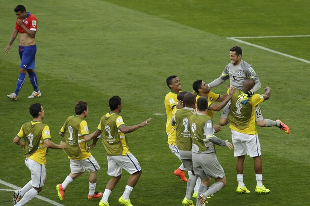 Brazil's goalkeeper Julio Cesar, top right, is congratulated by his teammates as Chile's Gonzalo Jara, top left, walks past after the World Cup round of 16 soccer match between Brazil and Chile at the Mineirao Stadium in Belo Horizonte, Brazil, Saturday, June 28, 2014. Brazil won 3-2 on penalties after the match ended 1-1 draw after extra-time. (AP Photo/Hassan Ammar)