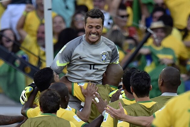 Brazil's goalkeeper Julio Cesar, centre, is greeted by teammates after a penalty  shoot out at the end of the World Cup round of 16 soccer match between Brazil and Chile at the Mineirao Stadium in Belo Horizonte, Brazil, Saturday, June 28, 2014. Brazil won the match 3-2 on penalties after the match ended 1-1. (AP Photo/Martin Meissner)