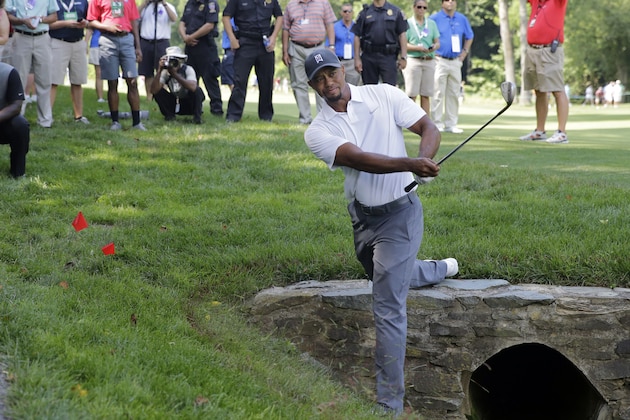 Tiger Woods hits out of the rough on the 11th hole during the second round of the Quicken Loans National PGA golf tournament, Friday, June 27, 2014, in Bethesda, Md. Woods finished the round at 7 over par for the tournament, and missed the cut. (AP Photo/Patrick Semansky)
