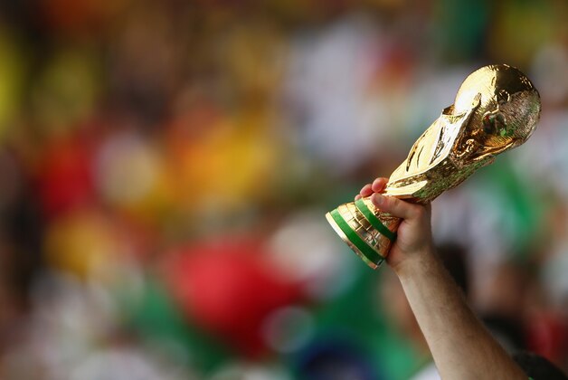 BELO HORIZONTE, BRAZIL - JUNE 17: A fan holds up a replica of the World Cup trophy during the 2014 FIFA World Cup Brazil Group H match between Belgium and Algeria at Estadio Mineirao on June 17, 2014 in Belo Horizonte, Brazil.  (Photo by Quinn Rooney/Getty Images)