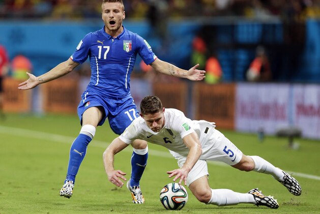 Italy's Ciro Immobile (17) backs away from England's Gary Cahill (5) as Cahill falls chasing the ball during the group D World Cup soccer match between England and Italy at the Arena da Amazonia in Manaus, Brazil, Saturday, June 14, 2014.  (AP Photo/Marcio Jose Sanchez)