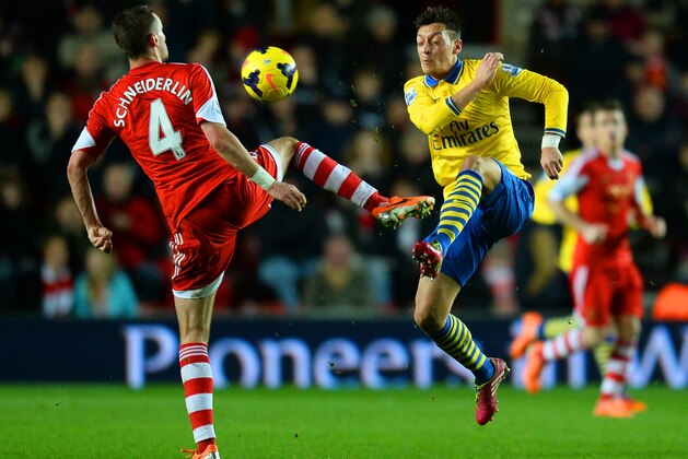 SOUTHAMPTON, ENGLAND - JANUARY 28: Morgan Schneiderlin of Southampton and Mesut Oezil of Arsenal compete for the ball during the Barclays Premier League match between Southampton and Arsenal at St Mary's Stadium on January 28, 2014 in Southampton, England.  (Photo by Mike Hewitt/Getty Images)