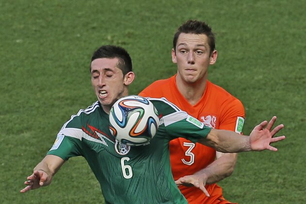 Mexico's Hector Herrera, left, and Netherlands' Stefan de Vrij challenge for the ball during the World Cup round of 16 soccer match between the Netherlands and Mexico at the Arena Castelao in Fortaleza, Brazil, Sunday, June 29, 2014. (AP Photo/Themba Hadebe)
