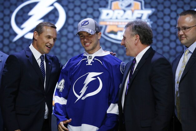 Anthony Deangelo stands with Tampa Bay Lightning officials after being chosen 19th overall during the first round of the NHL hockey draft, Friday, June 27, 2014, in Philadelphia. (AP Photo/Matt Slocum)