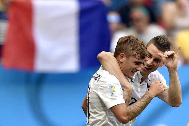 France's Antoine Griezmann, left, and Laurent Koscielny celebrate after Nigeria's Joseph Yobo scored an own goal during the World Cup round of 16 soccer match between France and Nigeria at the Estadio Nacional in Brasilia, Brazil, Monday, June 30, 2014. (AP Photo/Martin Meissner)