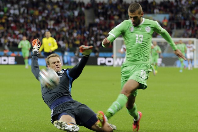 Germany's goalkeeper Manuel Neuer, left, slides in to make a save against Algeria's Islam Slimani during the World Cup round of 16 soccer match between Germany and Algeria at the Estadio Beira-Rio in Porto Alegre, Brazil, Monday, June 30, 2014. (AP Photo/Matthias Schrader)