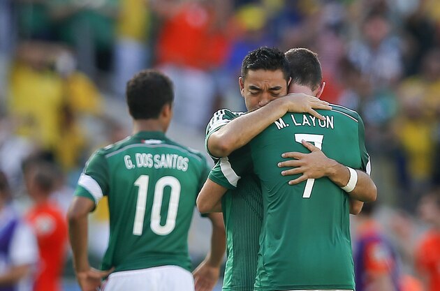 Mexico's Miguel Layun (7) is hugged by his teammate Marco Fabian after the Netherlands defeated Mexico 2-1 to advance to the quarterfinals during the World Cup round of 16 soccer match between the Netherlands and Mexico at the Arena Castelao in Fortaleza, Brazil, Sunday, June 29, 2014. (AP Photo/Eduardo Verdugo)