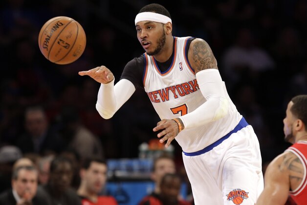 New York Knicks' Carmelo Anthony, left, passes the ball past Chicago Bulls' D.J. Augustin during the first half of the NBA basketball game, Sunday, April 13, 2014 in New York. The Knicks defeated the Bulls 100-89. (AP Photo/Seth Wenig)