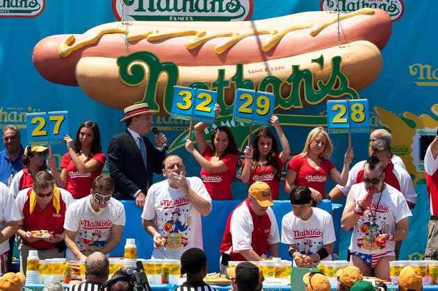 NEW YORK, NY - JULY 04:  Competitive eaters compete in the men's division of the Nathan's Famous International Hot Dog Eating Contest at Coney Island on July 4, 2012 in the Brooklyn borough of New York City. Joey Chestnut won the men's division by successfully tying his own world record by eating 68 hot dogs in 10 minutes; he has now won the competition six years in a row.  (Photo by Andrew Burton/Getty Images)