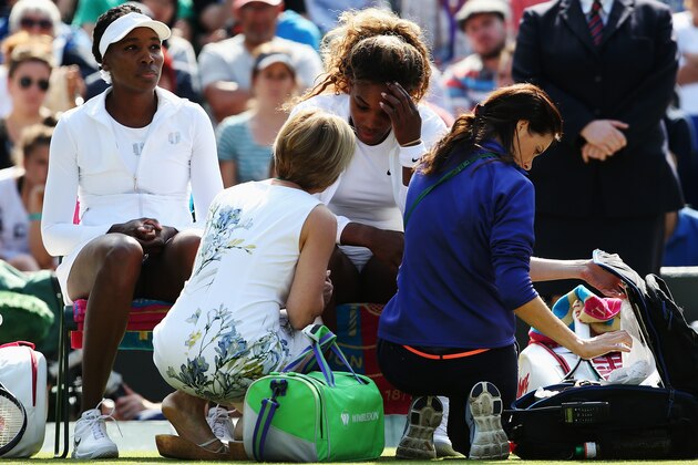 LONDON, ENGLAND - JULY 01:  Serena Williams of the United States recieves treatment during the warm up before their Ladies Doubles second round match with Venus Williams (l) against Kristina Barrois of Germany and Stefanie Voegele of Switzerland on day eight of the Wimbledon Lawn Tennis Championships at the All England Lawn Tennis and Croquet Club on July 1, 2014 in London, England.  (Photo by Jan Kruger/Getty Images)
