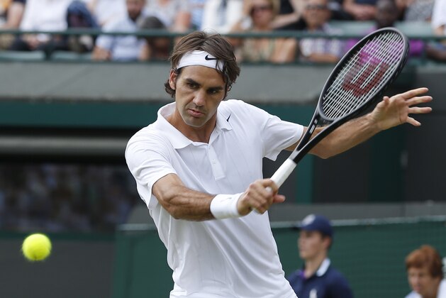 Roger Federer of Switzerland plays a return to Tommy Robredo of Spain in their men's singles match at the All England Lawn Tennis Championships in Wimbledon, London, Tuesday July 1, 2014. (AP Photo/Pavel Golovkin)