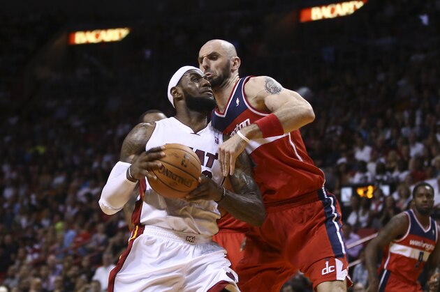 Washington Wizards' Marcin Gortat (4) blocks Miami Heat's LeBron James (6) during the first half of an NBA  basketball game in Miami, Monday, March 10, 2014. (AP Photo/J Pat Carter)