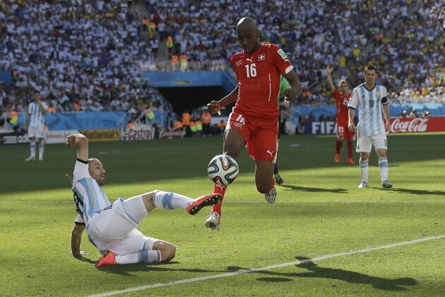 Switzerland's Gelson Fernandes is challenged by Argentina's Rodrigo Palacio, left, during the World Cup round of 16 soccer match between Argentina and Switzerland at the Itaquerao Stadium in Sao Paulo, Brazil, Tuesday, July 1, 2014. (AP Photo/Sergei Grits)