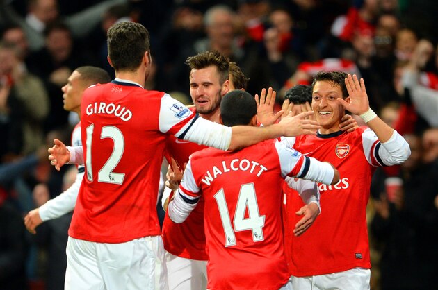 LONDON, ENGLAND - DECEMBER 08:  Mesut Oezil of Arsenal celebrates scoring their first goal with team mates during the Barclays Premier League match between Arsenal and Everton at Emirates Stadium on December 8, 2013 in London, England.  (Photo by Michael Regan/Getty Images)