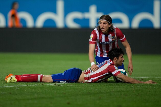 MADRID, SPAIN - APRIL 18: Filipe Luis (R) of Atletico de Madrid assists his teammate Diego Costa (L) after being tackled by Cristian Sapunaru of Elche FC  during the La Liga match between Club Atletico de Madrid and Elche FC at Vicente Calderon Stadium on April 18, 2014 in Madrid, Spain.  (Photo by Gonzalo Arroyo Moreno/Getty Images)