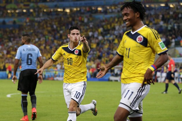 Colombia's James Rodriguez (10) celebrates with his teammate Juan Cuadrado (11) after he scored his side's second goal during the World Cup round of 16 soccer match between Colombia and Uruguay at the Maracana Stadium in Rio de Janeiro, Brazil, Saturday, June 28, 2014. (AP Photo/Marcio Jose Sanchez)
