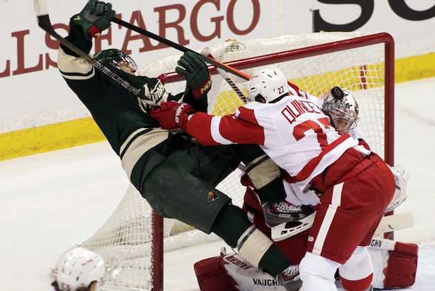 Minnesota Wild left wing Zach Parise (11) is checked hard by Detroit Red Wings defenseman Kyle Quincey (27) during the first period of an NHL hockey game, Saturday, March 22, 2014, in St. Paul, Minn. (AP Photo/Paul Battaglia)