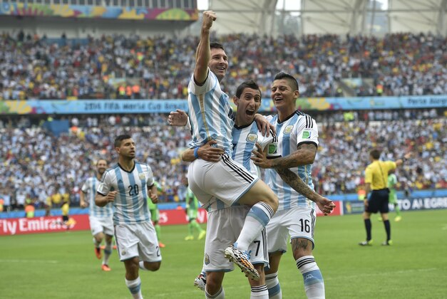 Argentina's Lionel Messi, left, is carried by his teammates Argentina's Angel di Maria (7) and Argentina's Marcos Rojo after scoring his side's first goal during the group F World Cup soccer match between Nigeria and Argentina at the Estadio Beira-Rio in Porto Alegre, Brazil, Wednesday, June 25, 2014. (AP Photo/Martin Meissner)