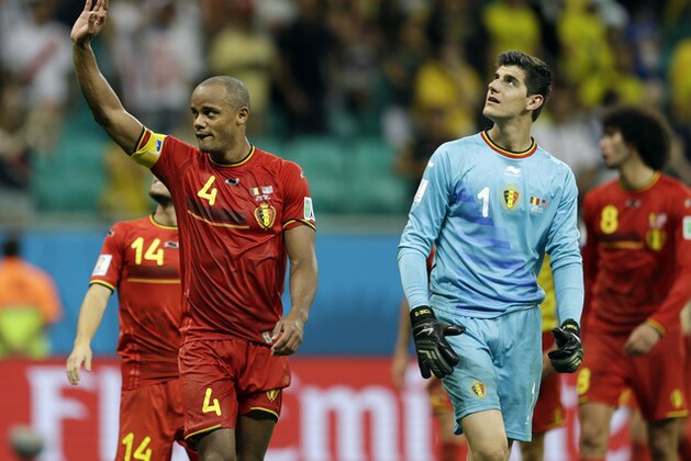 Belgium's Vincent Kompany and teammate goalkeeper Thibaut Courtois walk off the pitch after Belgium defeated the USA 2-1 in extra time to advance to the quarterfinals during the World Cup round of 16 soccer match between Belgium and the USA at the Arena Fonte Nova in Salvador, Brazil, Tuesday, July 1, 2014. (AP Photo/Natacha Pisarenko)