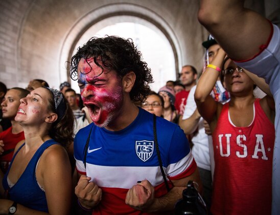 NEW YORK, NY - JULY 01:  Christian Raja, of Brooklyn, reacts while watching the United States versus Belgium game in the World Cup on a projected screen under the Manhattan Bridge on July 1, 2014 in the Dumbo neighborhood of the Brooklyn borough of New York, United States. Belgium went on to eliminate the U.S. from the World Cup in overtime with a final score 2-1.  (Photo by Andrew Burton/Getty Images)