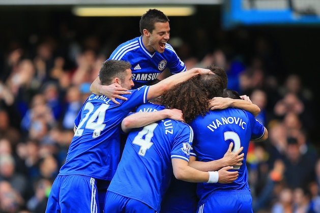 LONDON, ENGLAND - MARCH 22:  Eden Hazard of Chelsea is mobbed by team mates after scoring their fourth goal from the penalty spot during the Barclays Premier League match between Chelsea and Arsenal at Stamford Bridge on March 22, 2014 in London, England.  (Photo by Richard Heathcote/Getty Images)