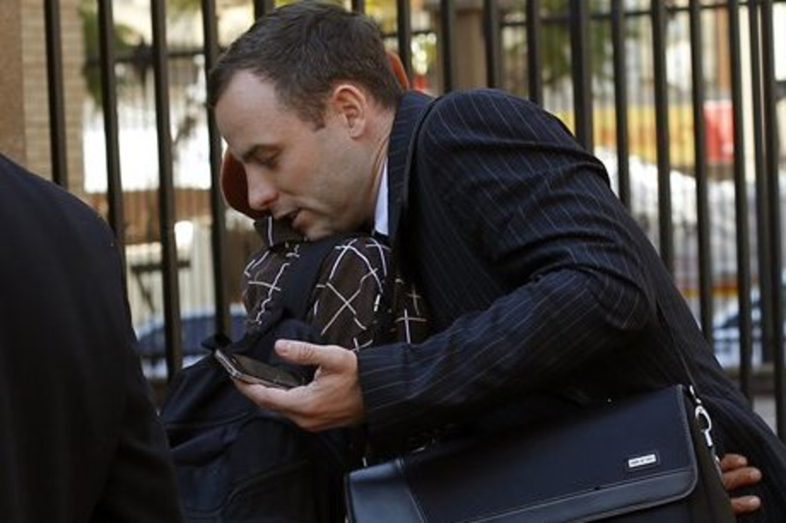 Oscar Pistorius, hugs a well-wisher as he returns to court following a lunch break in Pretoria, South Africa, Wednesday, July 2, 2014. Pistorius is severely traumatized after killing girlfriend Reeva Steenkamp last year and will become an increasing suicide risk unless he continues to get mental health care, the judge overseeing his murder trial heard on Wednesday. Defense lawyer Barry Roux read excerpts from a psychologist's report that said the double-amputee runner is suffering depression and post-traumatic stress disorder and