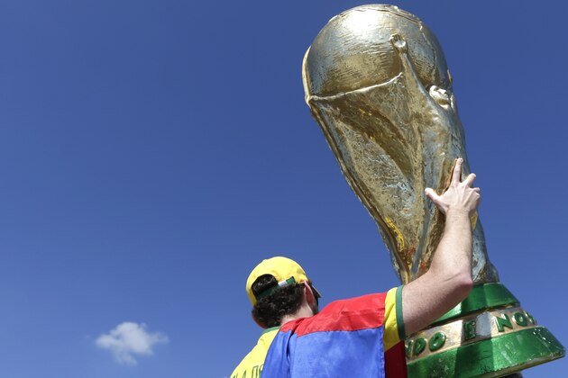 A fan of Brazil national soccer team holds up a replica of World Cup trophy prior the World Cup round of 16 match between Brazil and Chile at the Mineirao Stadium in Belo Horizonte, Brazil, Saturday, June 28, 2014. (AP Photo/Petr David Josek)