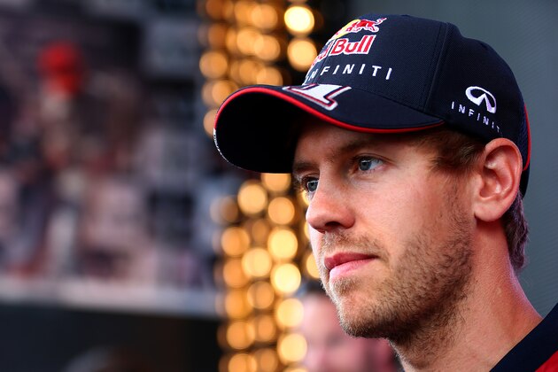 SPIELBERG, AUSTRIA - JUNE 19:  Sebastian Vettel of Germany and Infiniti Red Bull Racing looks on as he signs autographs for fans ahead of the Austrian Formula One Grand Prix at Red Bull Ring on June 19, 2014 in Spielberg, Austria.  (Photo by Mark Thompson/Getty Images)