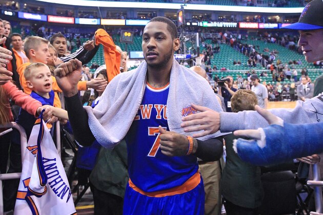 Fans reach for New York Knicks' Carmelo Anthony (7) as he walks off the court following their NBA basketball game against the Utah Jazz Monday, March 31, 2014, in Salt Lake City. The Knicks won 92-83. (AP Photo/Rick Bowmer)