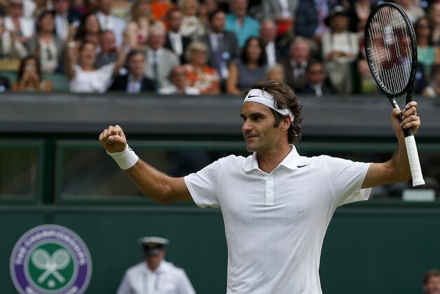 Roger Federer of Switzerland celebrates as he defeats Stan Wawrinka of Switzerland in their men's singles quarterfinal match at the All England Lawn Tennis Championships in Wimbledon, London, Wednesday, July 2, 2014. (AP Photo/Pavel Golovkin)