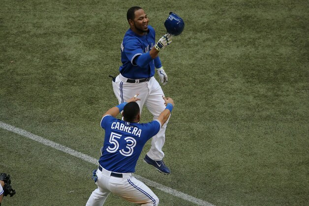 TORONTO, CANADA - JULY 2: Edwin Encarnacion #10 of the Toronto Blue Jays is congratulated by Melky Cabrera #53 after hitting a game-winning three-run home run in the ninth inning during MLB game action against the Milwaukee Brewers on July 2, 2014 at Rogers Centre in Toronto, Ontario, Canada. (Photo by Tom Szczerbowski/Getty Images)