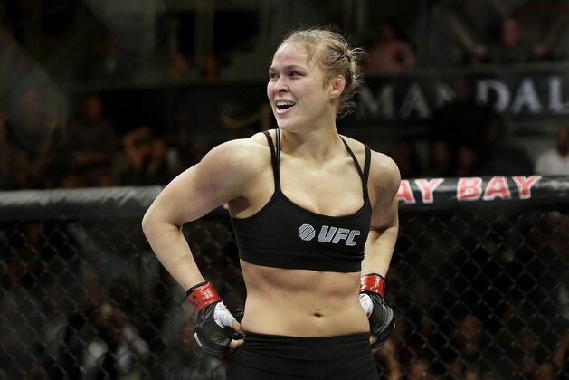 FILE - In this Feb. 22, 2014, file photo, Ronda Rousey looks around after defeating Sara McMann in a UFC 170 mixed martial arts women's bantamweight title bout in Las Vegas. Gina Carano was scheduled to meet with UFC President Dana White on Wednesday April 9, to discuss a return to mixed martial arts for a potential bout with bantamweight champion Rousey. (AP Photo/Isaac Brekken, File)