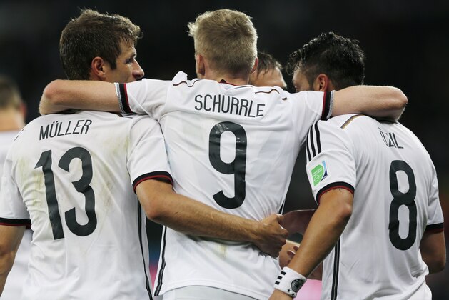 Germany's Mesut Ozil celebrates with this teammates Thomas Mueller and Andre Schuerrle after scoring his side's second goal in extra time during the World Cup round of 16 soccer match between Germany and Algeria at the Estadio Beira-Rio in Porto Alegre, Brazil, Monday, June 30, 2014. Germany defeated Algeria 2-1 to advance to the quarterfinals.  (AP Photo/Matthias Schrader)