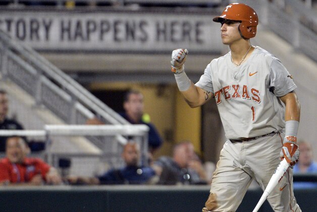Texas' Tres Barrera celebrates a run against Vanderbilt on a single by Zane Gurwitz in the sixth inning of an NCAA baseball College World Series game in Omaha, Neb., Saturday, June 21, 2014. (AP Photo/Ted Kirk)