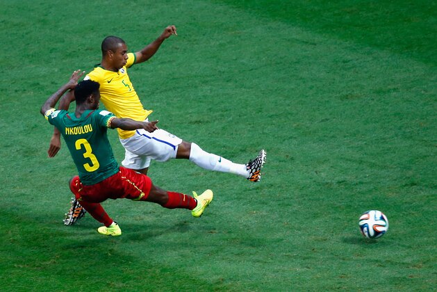 BRASILIA, BRAZIL - JUNE 23: Fernandinho of Brazil scores his team's fourth goal against Nicolas N'Koulou of Cameroon during the 2014 FIFA World Cup Brazil Group A match between Cameroon and Brazil at Estadio Nacional on June 23, 2014 in Brasilia, Brazil.  (Photo by Phil Walter/Getty Images)