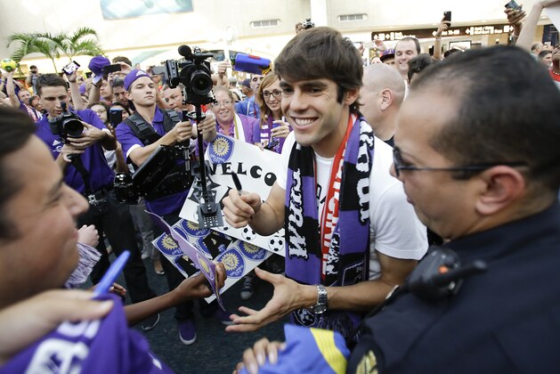 Brazilian soccer star Kaka, center, signs autographs as he is surrounded by fans at Orlando International Airport, Monday, June 30, 2014, in Orlando, Fla. Kaka is the first designated player to sign with the Orlando City Soccer Club that will begin play in Major League Soccer in 2015. (AP Photo/John Raoux)