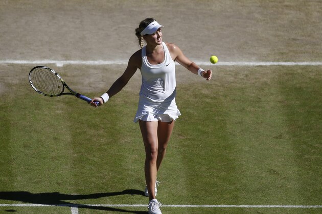 Eugenie Bouchard of Canada hits a ball into the crowd as she celebrates after defeating Simona Halep of Romania in their women's singles semifinal match at the All England Lawn Tennis Championships in Wimbledon, London, Thursday, July 3, 2014. Bouchard will play Petra Kvitova of Czech Republic in the women's final Saturday. (AP Photo/Sang Tan, Pool)