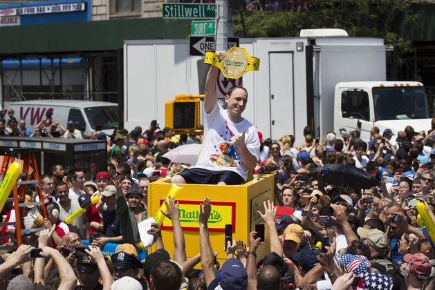 Joey Chestnut, six time winner of the Nathan's Famous Fourth of July International Hot Dog Eating contest, is carried to the competition stage through a crowd of fans, Thursday, July 4, 2013 at Coney Island, in the Brooklyn borough of New York. (AP Photo/John Minchillo)