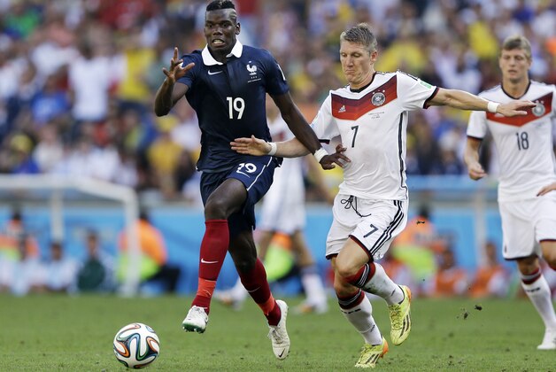 Germany's Bastian Schweinsteiger tries to slow France's Paul Pogba's attack during the World Cup quarterfinal soccer match at the Maracana Stadium in Rio de Janeiro, Brazil, Friday, July 4, 2014. (AP Photo/Kirsty Wigglesworth)