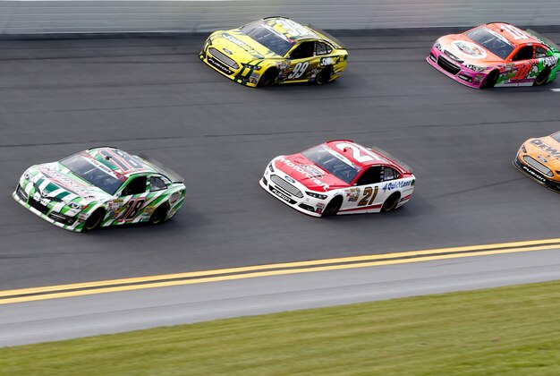 Jul 3, 2014; Daytona Beach, FL, USA; NASCAR Sprint Cup Series driver Kyle Busch (18) leads a pack of cars through turn four during practice for the Coke Zero 400 at Daytona International Speedway. Mandatory Credit: Rob Foldy-USA TODAY Sports