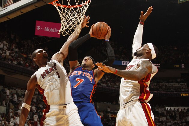 MIAMI, FL - MAY 09:  Carmelo Anthony #7 of the New York Knicks goes to the basket against Chris Bosh #1 and LeBron James #6 of the Miami Heat in Game Five of the Eastern Conference Quarterfinals during the 2012 NBA Playoffs on May 9, 2012 at American Airlines Arena in Miami, Florida. NOTE TO USER: User expressly acknowledges and agrees that, by downloading and or using this photograph, User is consenting to the terms and conditions of the Getty Images License Agreement. Mandatory Copyright Notice: Copyright 2012 NBAE  (Photo by Issac Baldizon/NBAE via Getty Images)