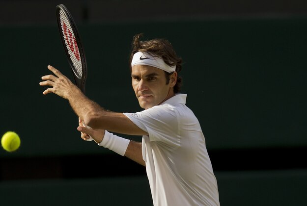 Jul 4, 2014; London, United Kingdom; Roger Federer (SUI) in action during his match against Milos Raonic (CAN) on day 11 of the 2014 Wimbledon Championships at the All England Lawn and Tennis Club. Mandatory Credit: Susan Mullane-USA TODAY Sports