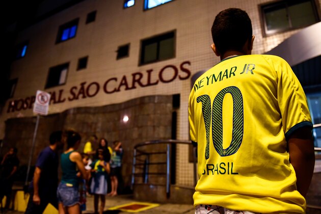 FORTALEZA, BRAZIL - JULY 04: Brazil football fan stay outside Sao Carlos Hospital where superstar striker Neymar was treated after being injured during the quarter-final football match between Brazil and Colombia at the Castelao Stadium in Fortaleza during the 2014 FIFA World Cup on July 4, 2014. Brazil star Neymar was ruled out of the World Cup after that with a back injury, team doctor Rodrigo Lasmar said. Lasmar told reporters Neymar suffered a fracture in the third verterbra of his back during Brazil's bruising 2-1 quarter-final victory over Colombia. (Photo by Buda Mendes/Getty Images) FORTALEZA, BRAZIL - JULY 04: Brazil football fan stay outside Sao Carlos Hospital where superstar striker Neymar was treated after being injured during the quarter-final football match between Brazil and Colombia at the Castelao Stadium in Fortaleza during the 2014 FIFA World Cup on July 4, 2014. Brazil star Neymar was ruled out of the World Cup after that with a back injury, team doctor Rodrigo Lasmar said. Lasmar told reporters Neymar suffered a fracture in the third verterbra of his back during Brazil's bruising 2-1 quarter-final victory over Colombia. (Photo by Buda Mendes/Getty Images)