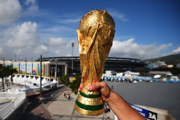 RIO DE JANEIRO, BRAZIL - JUNE 11:  A fan holds a replica of the World Cup Trophy near the Maracana Stadium on June 11, 2014 in Rio de Janeiro, Brazil.  (Photo by Matthias Hangst/Getty Images)