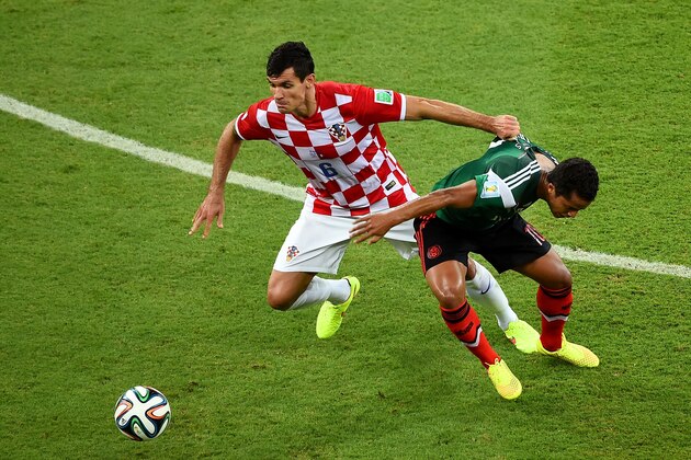 RECIFE, BRAZIL - JUNE 23:  Dejan Lovren of Croatia fights off Giovani dos Santos of Mexico during the 2014 FIFA World Cup Brazil Group A match between Croatia and Mexico at Arena Pernambuco on June 23, 2014 in Recife, Brazil.  (Photo by Laurence Griffiths/Getty Images)