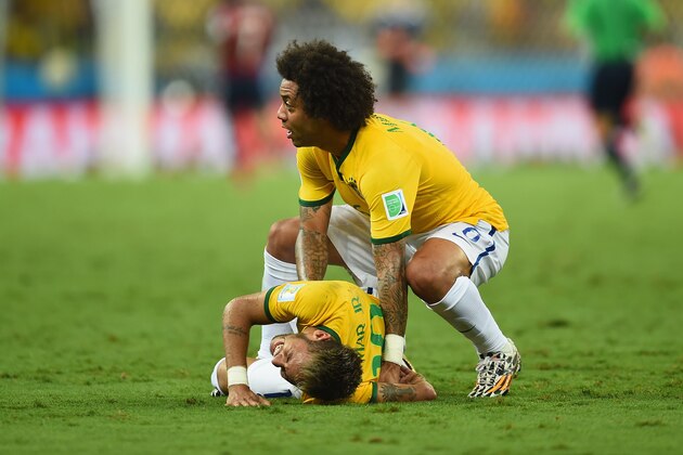 FORTALEZA, BRAZIL - JULY 04:  Neymar of Brazil lies on the field after a challenge as teammate Marcelo reacts during the 2014 FIFA World Cup Brazil Quarter Final match between Brazil and Colombia at Castelao on July 4, 2014 in Fortaleza, Brazil.  (Photo by Jamie McDonald/Getty Images)